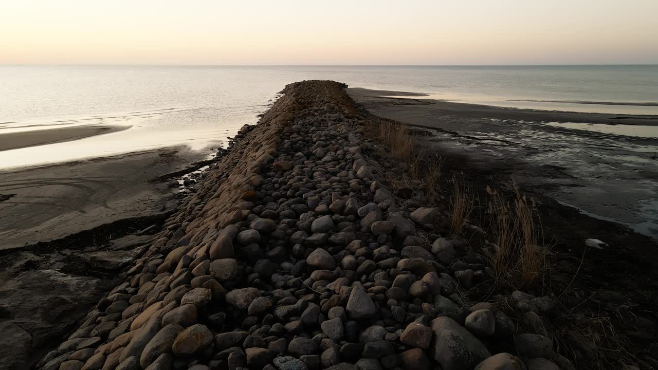 海岸上的岩石山，日落在海洋，海滩和地平线的背景视频素材