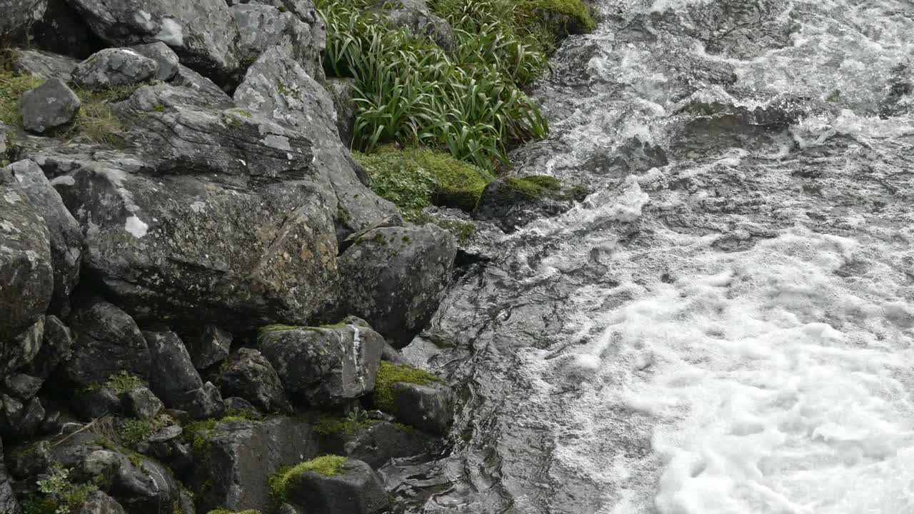 山间溪流，涌动着能量的泡沫，迅速流过岩石地貌。帕诺人视频素材