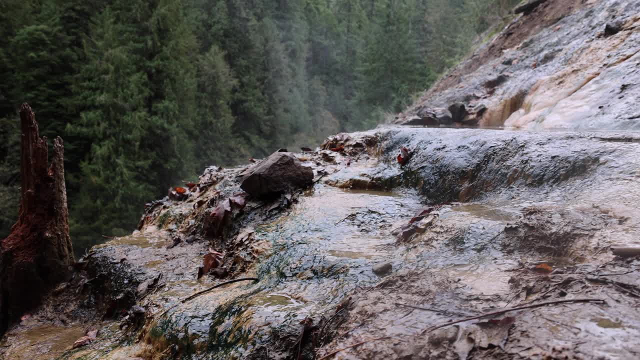 泥泞的山坡上有一股水流流下视频素材