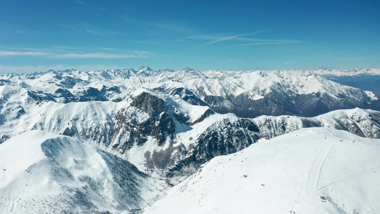 蓝天下白雪覆盖的山峰，广阔的山脉景观，白天视频素材