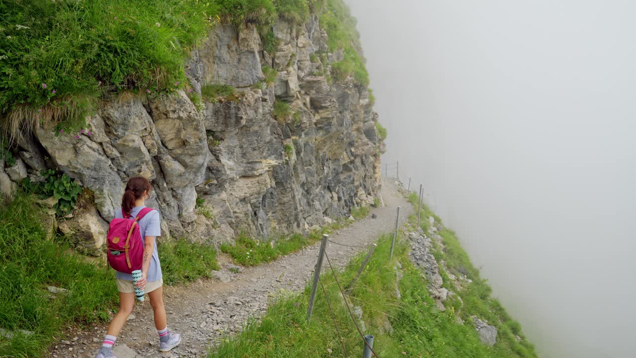 一名妇女在瑞士阿尔卑斯山的浓雾中徒步旅行视频素材