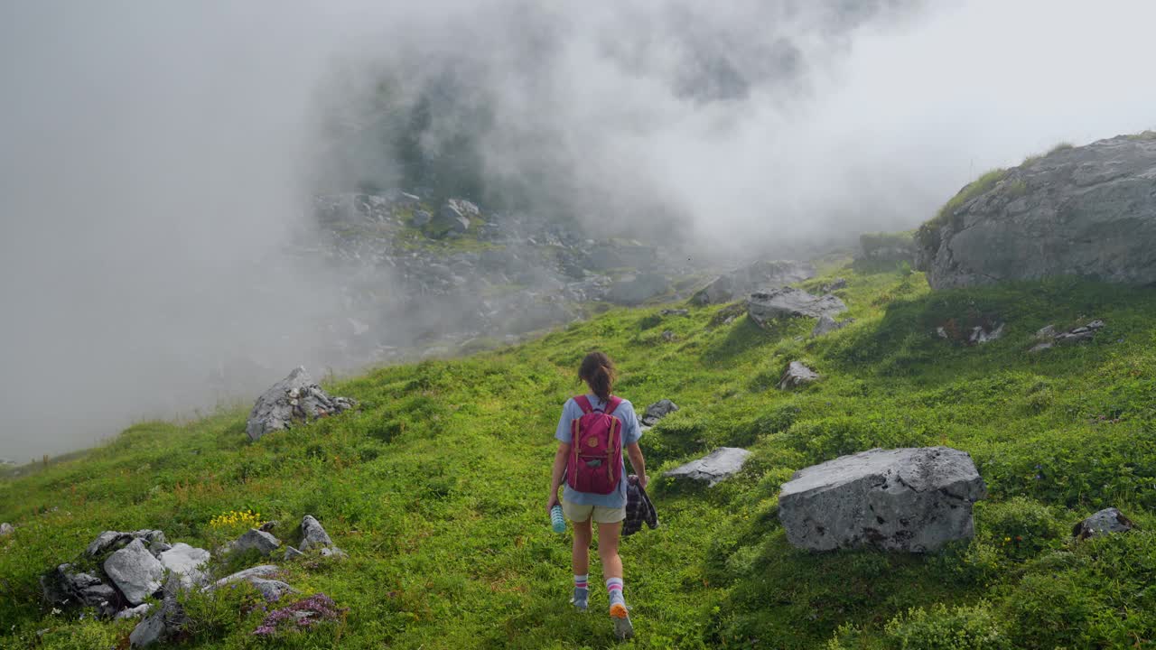 一名妇女在瑞士阿尔卑斯山的浓雾中徒步旅行视频素材