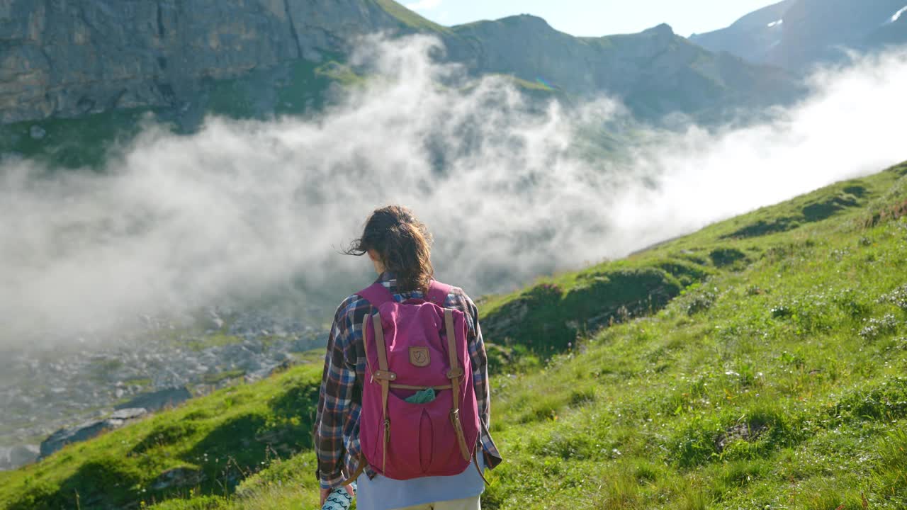 一名妇女在瑞士阿尔卑斯山的浓雾中徒步旅行视频素材