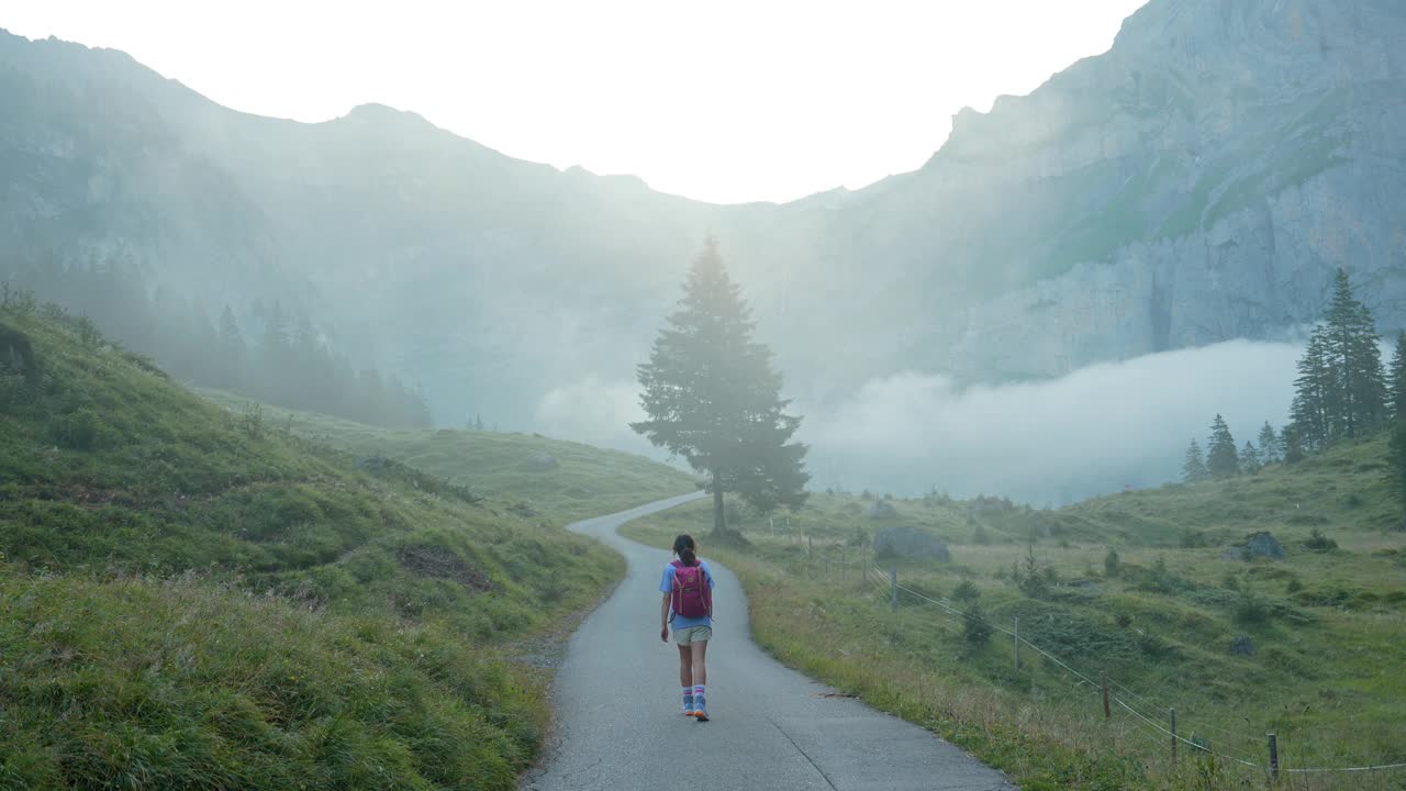 一名妇女在瑞士阿尔卑斯山的浓雾中徒步旅行视频素材