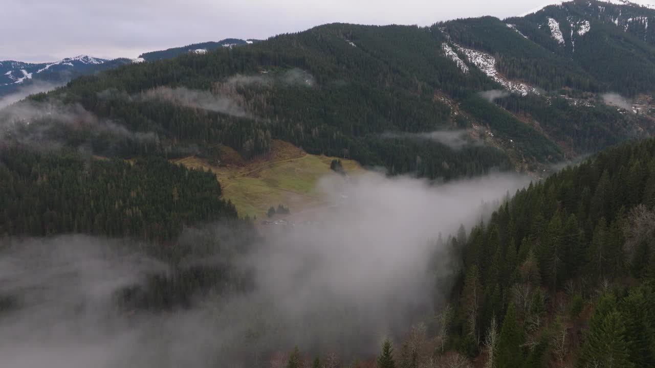 奥地利萨尔巴赫-辛特格莱姆(saalbach - hinterglmm)，云雾缭绕的山脉上有绿色的斜坡视频素材