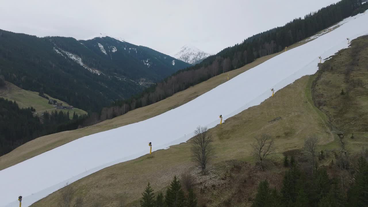 滑雪者在saalbach - hinterglmm(奥地利)的部分积雪覆盖的斜坡上下降，季节的对比视频素材