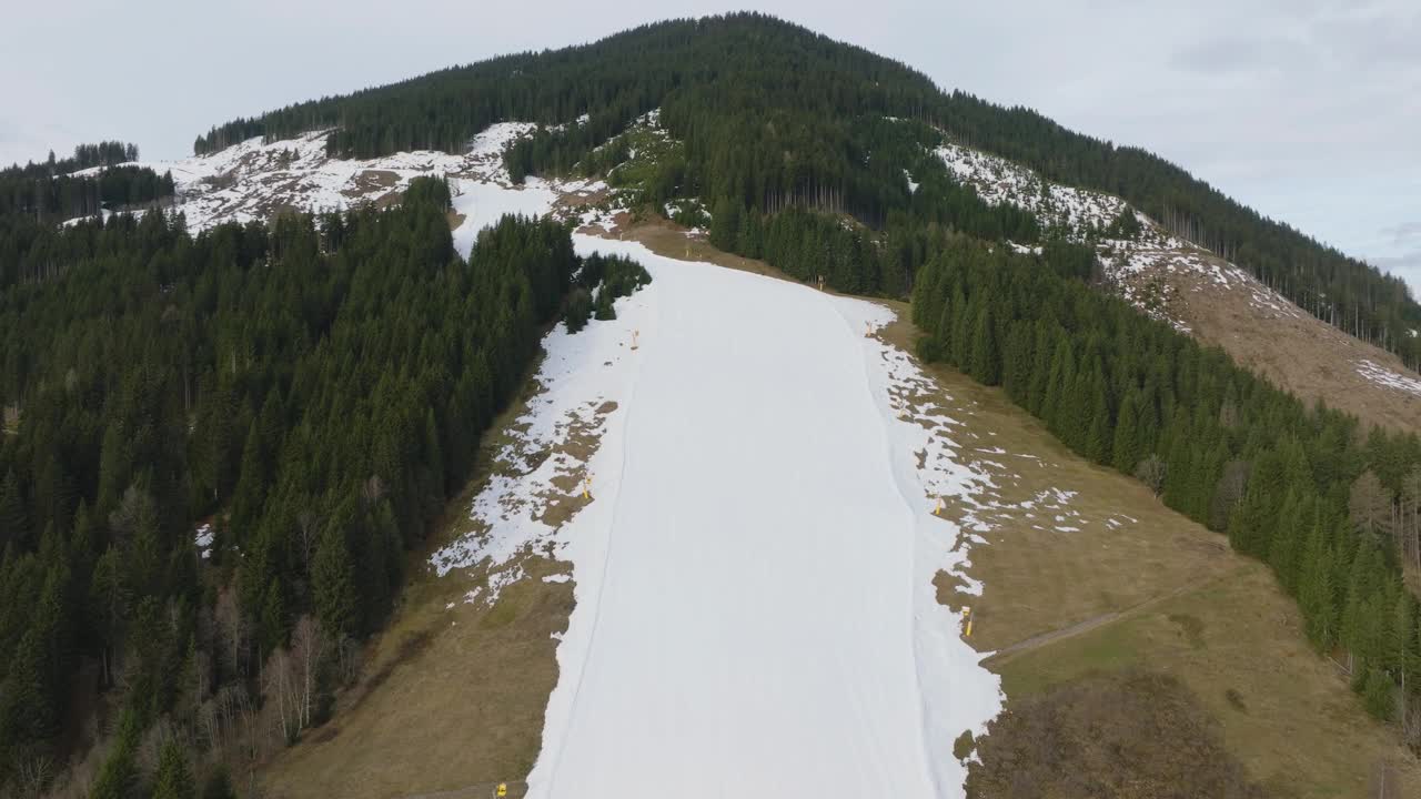 从空中俯瞰，奥地利的萨尔巴赫-辛特格勒姆滑雪胜地，早晨的雪正在融化视频素材