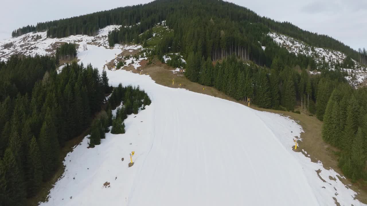 空中拍摄的萨尔巴赫-辛特格莱姆滑雪场在奥地利融化的雪，显示从冬天到春天的过渡，上升视图视频素材