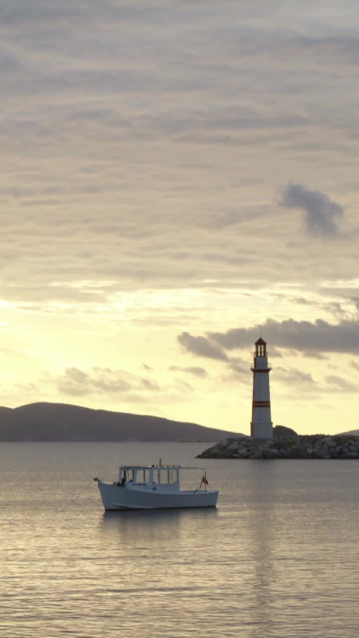 日落时的海景。海岸上的灯塔。海滨小镇Turgutreis和壮观的日落。社交媒体的垂直视频。视频素材