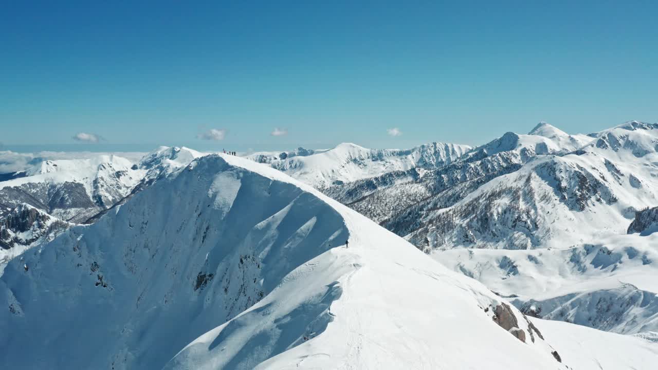 白雪皑皑的山峰下，湛蓝的天空，全景拍摄在明亮的日光视频素材