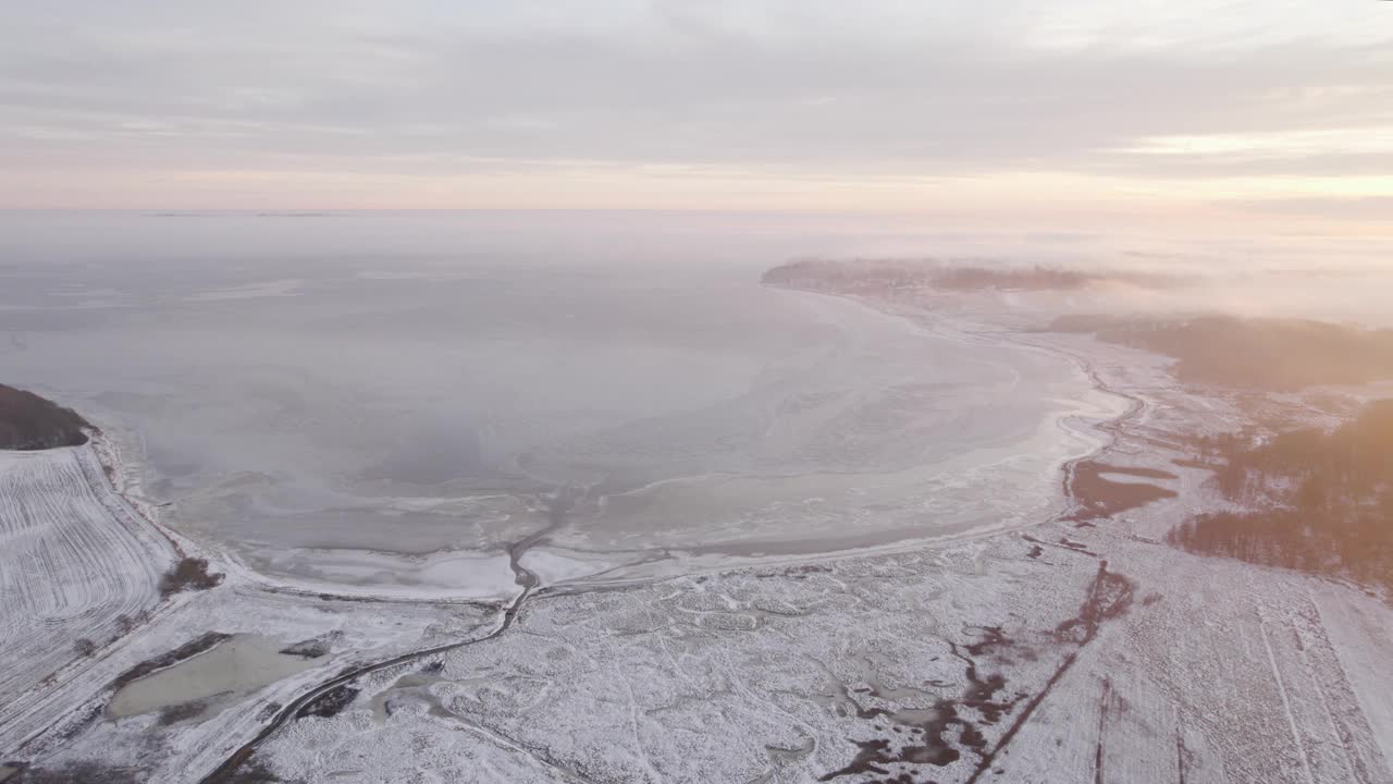 鸟瞰图的海岸覆盖着冰雪在冬天的日出。视频素材