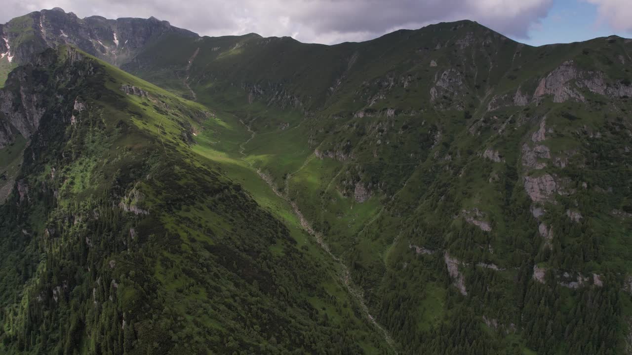 郁郁葱葱的蒂加内斯蒂山谷在布塞吉山脉下动态的天空，鸟瞰视频素材