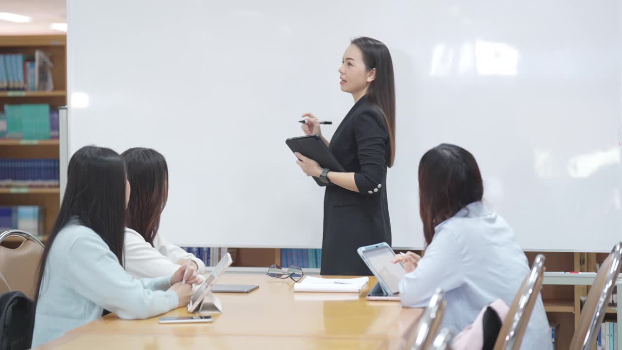 一位女士正在给一群人做报告视频素材