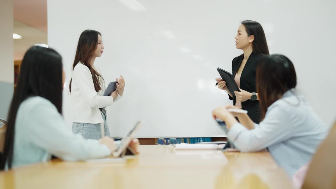 一群妇女围着一张桌子坐着，前面放着一块白板视频素材