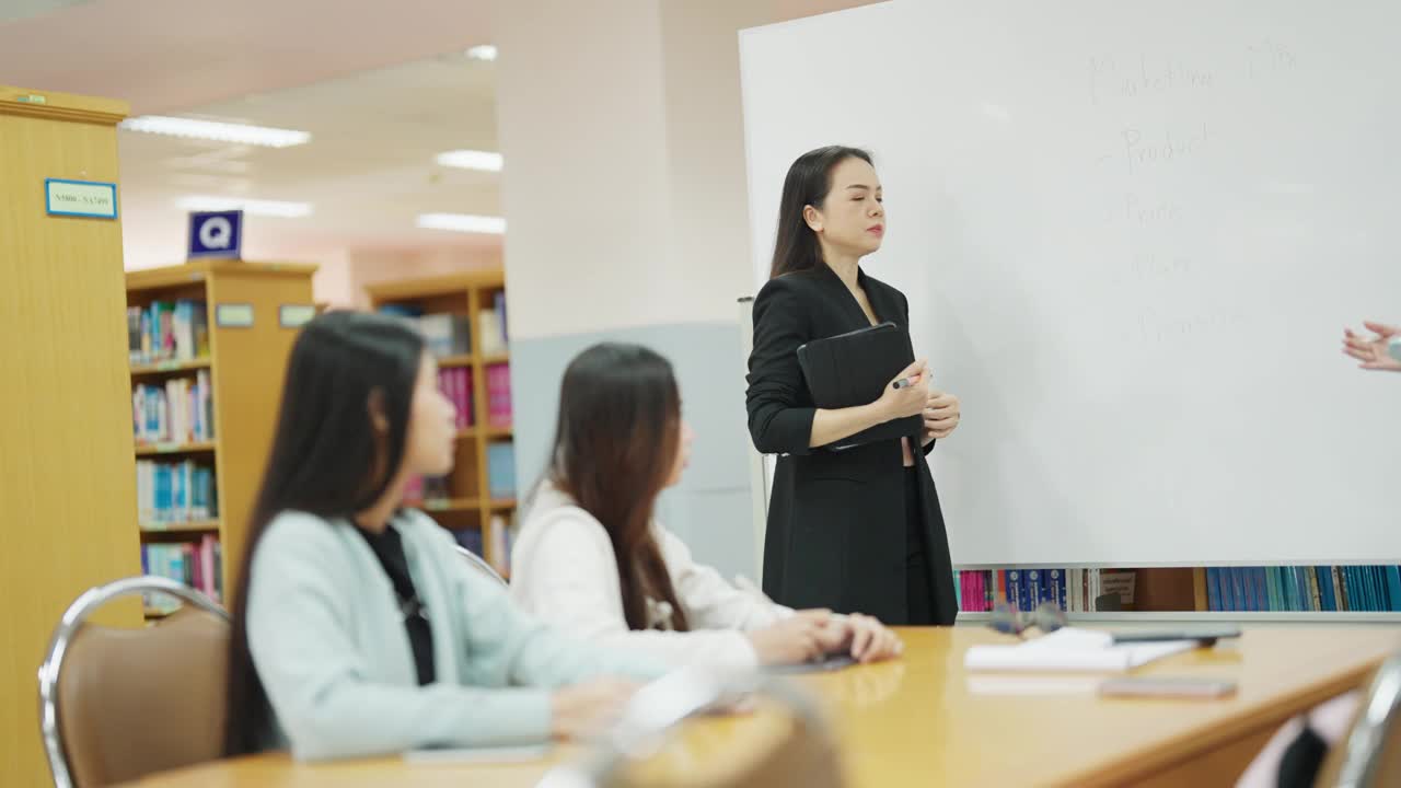 一个女人站在一块白板前和一群女人说话视频素材