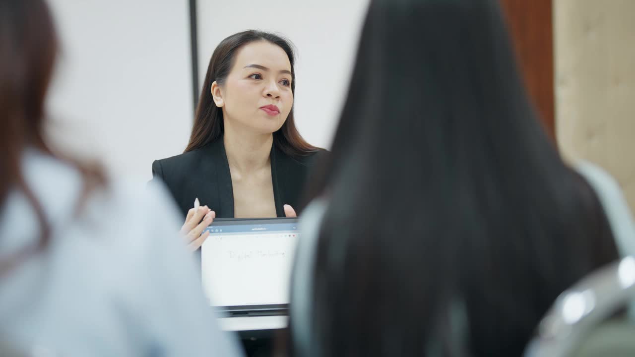 一位女士正在给一群人做报告视频素材