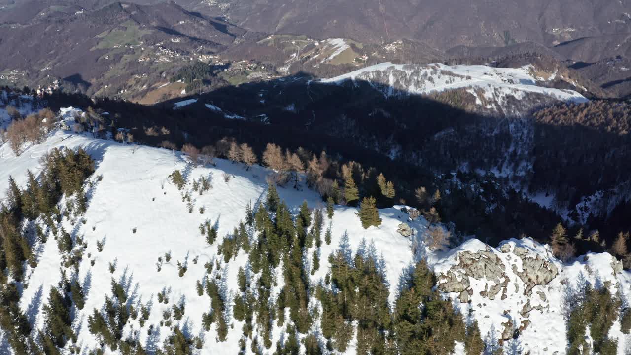 航拍的白雪覆盖的山，绿色的松树和山谷视频素材