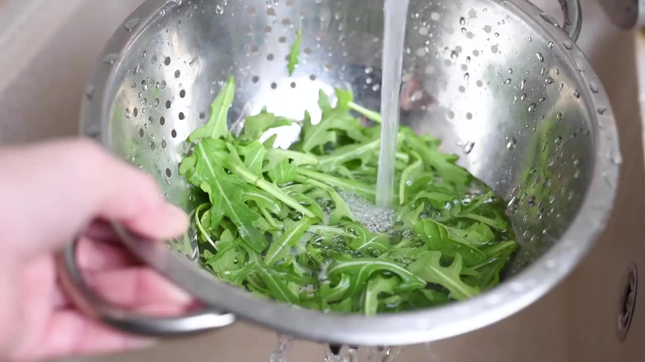 新鲜的芝麻菜叶子在水下清洗视频素材