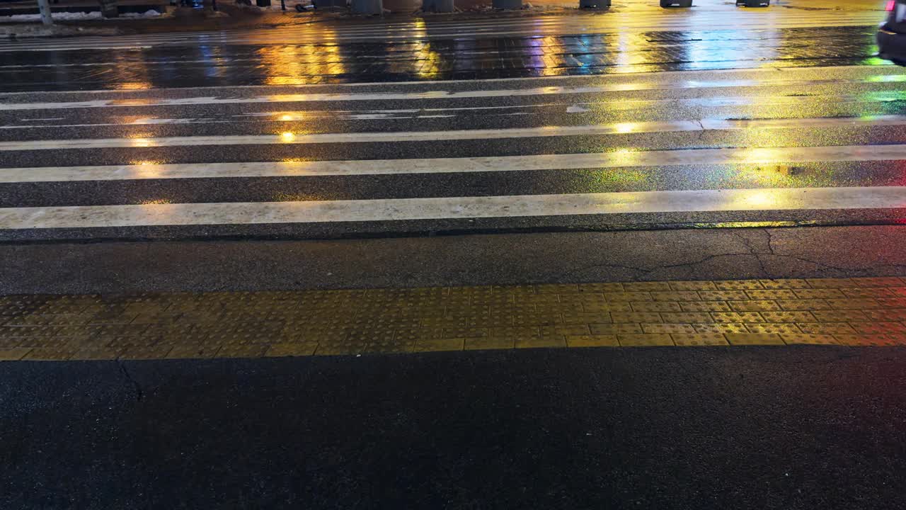 夜晚雨中的人行横道，地面上有灯光的反射视频素材