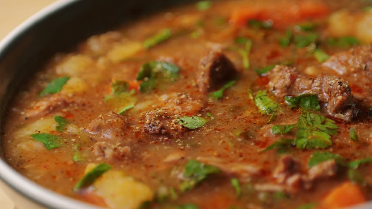 匈牙利炖牛肉汤在锅中烹饪特写，厨师在餐厅烹饪传统的波兰或捷克汤。视频素材