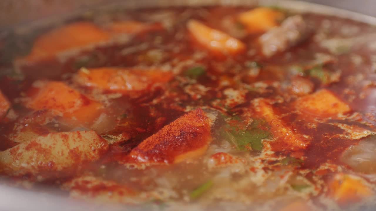 匈牙利炖牛肉汤在锅中烹饪特写，厨师在餐厅烹饪传统的波兰或捷克汤。视频素材