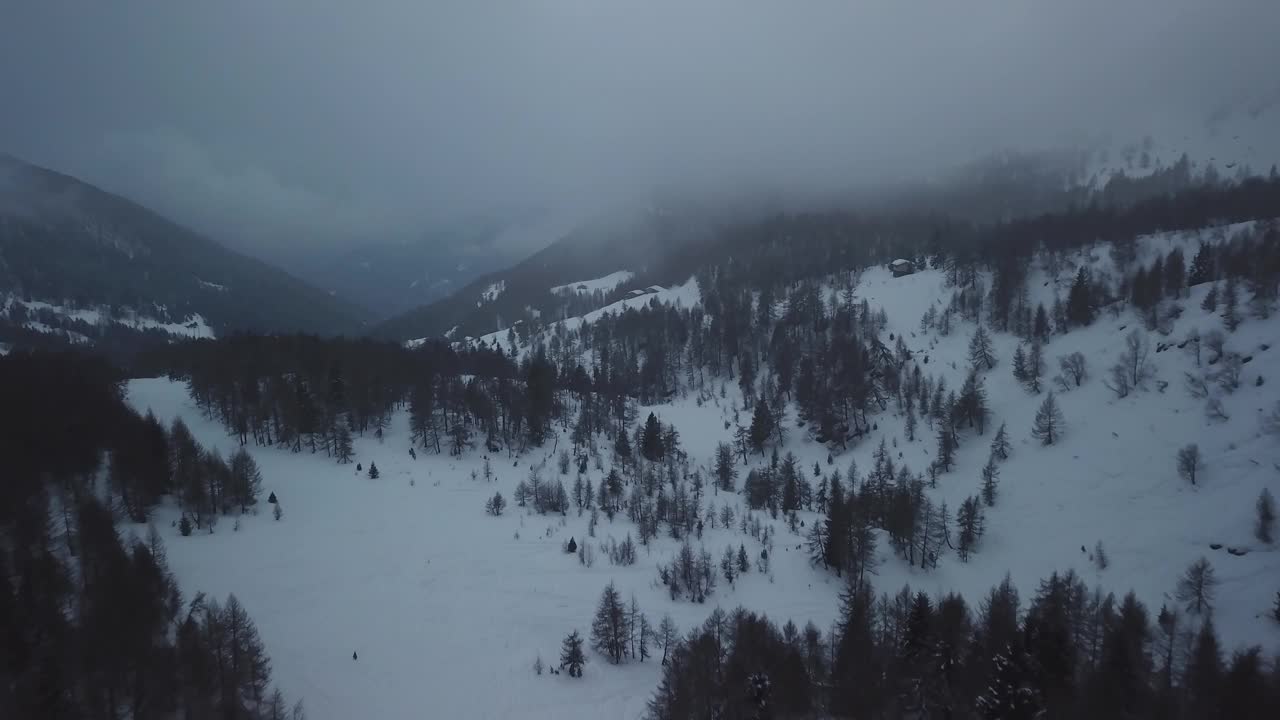 空中无人机拍摄的雪山景观。飞过冰冻的松林。粗糙的霜冻天性。戏剧性的雾天。令人惊叹的冬季全景。视频素材