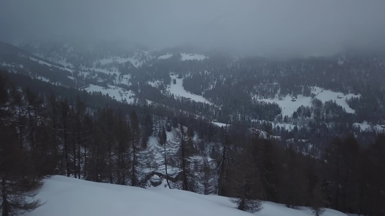 空中无人机拍摄的雪山景观。飞过冰冻的松林。粗糙的霜冻天性。戏剧性的雾天。令人惊叹的冬季全景。视频素材