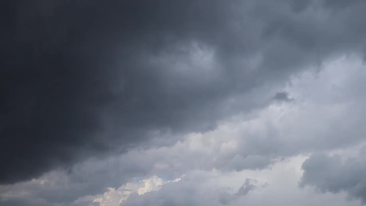 乌云慢慢地飘过天空。预示要下雨的雨云。阴雨天气里神奇的天空视频下载