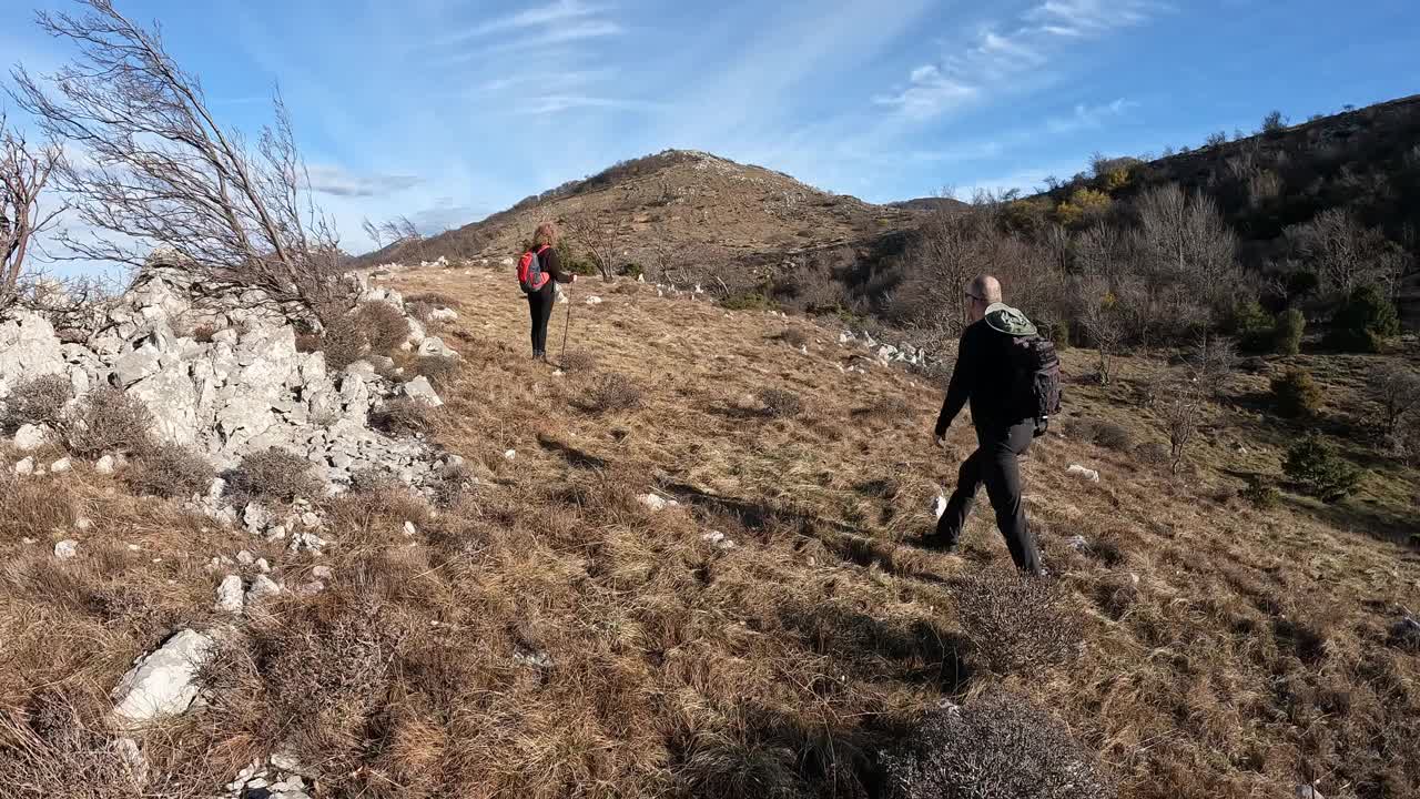 一对在山脊上徒步旅行的成熟夫妇视频素材