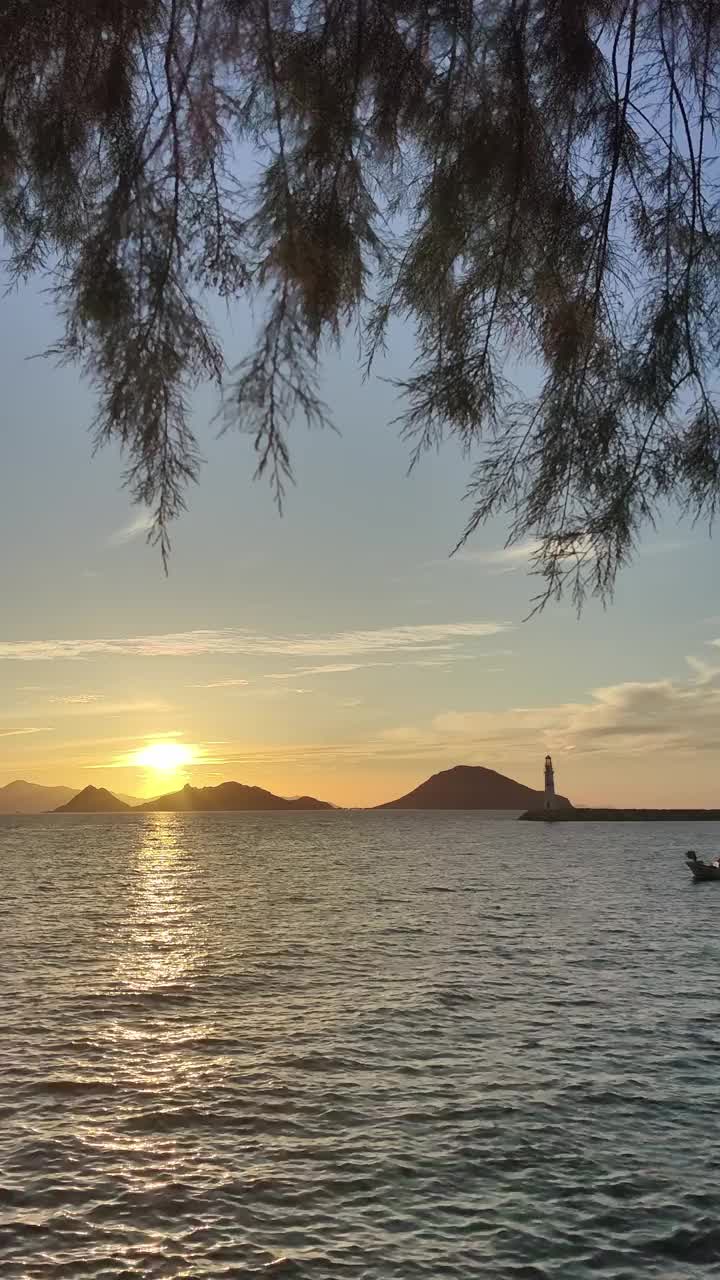 日落时的海景。海岸上的灯塔。海滨小镇Turgutreis和壮观的日落。社交媒体的垂直视频。视频素材