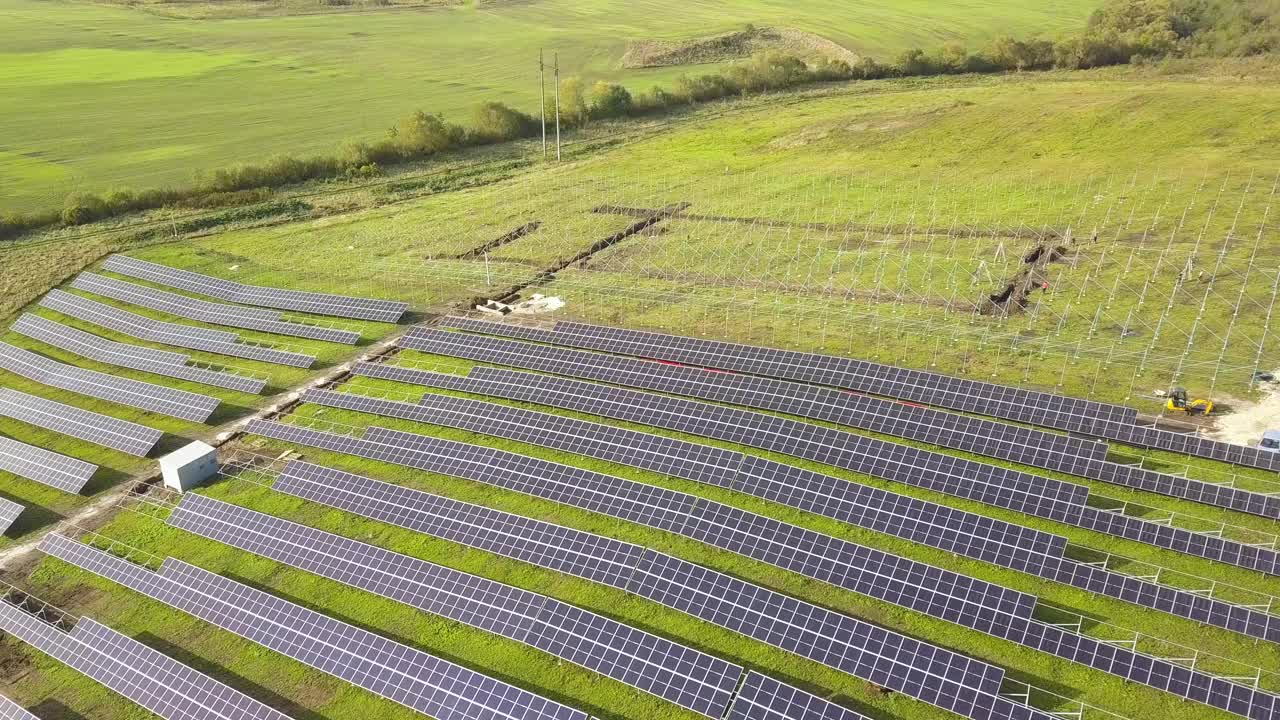 绿地上正在建设的太阳能发电厂鸟瞰图。组装用于生产清洁生态能源的电板。视频素材