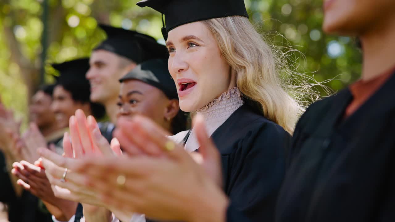 在学院或大学的校园里，学生们为庆祝毕业或取得学业成绩而鼓掌。微笑，研究生奖学金或兴奋的社区鼓掌，自然为班级的成功视频素材