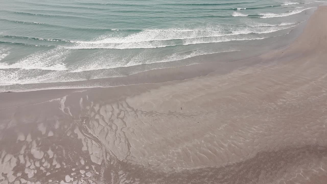 沙滩上的沙子，海浪，大海。沙滩和海面上的白色泡沫，无人机拍摄的视频。海景。视频素材