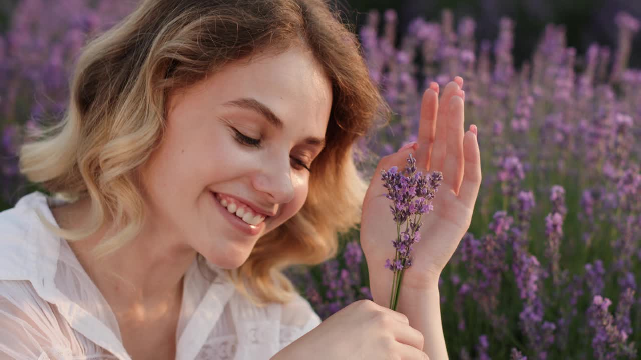 快乐的年轻女子在黄昏享受薰衣草花香视频素材