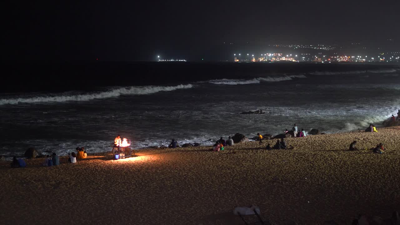 Ramakrishna海滩/ RK海滩夜间的视频片段显示了人们和海浪冲击海岸线视频素材