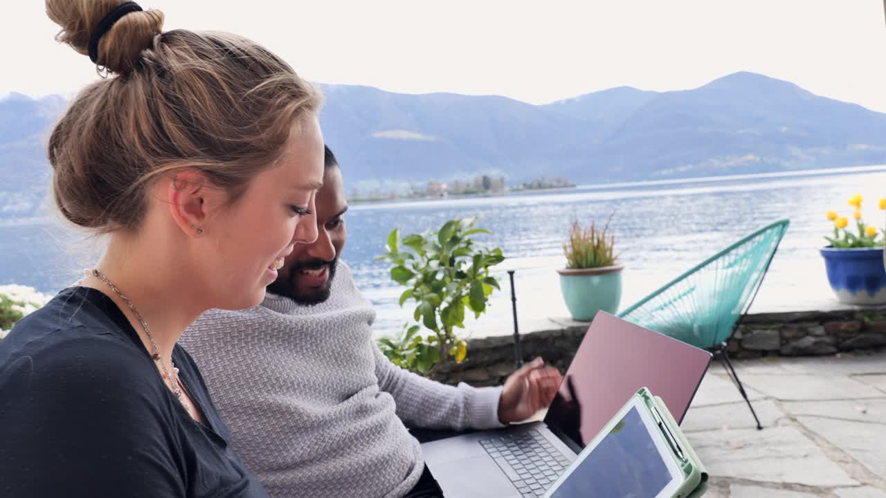 一男一女同事用笔记本电脑和平板电脑远程办公视频素材