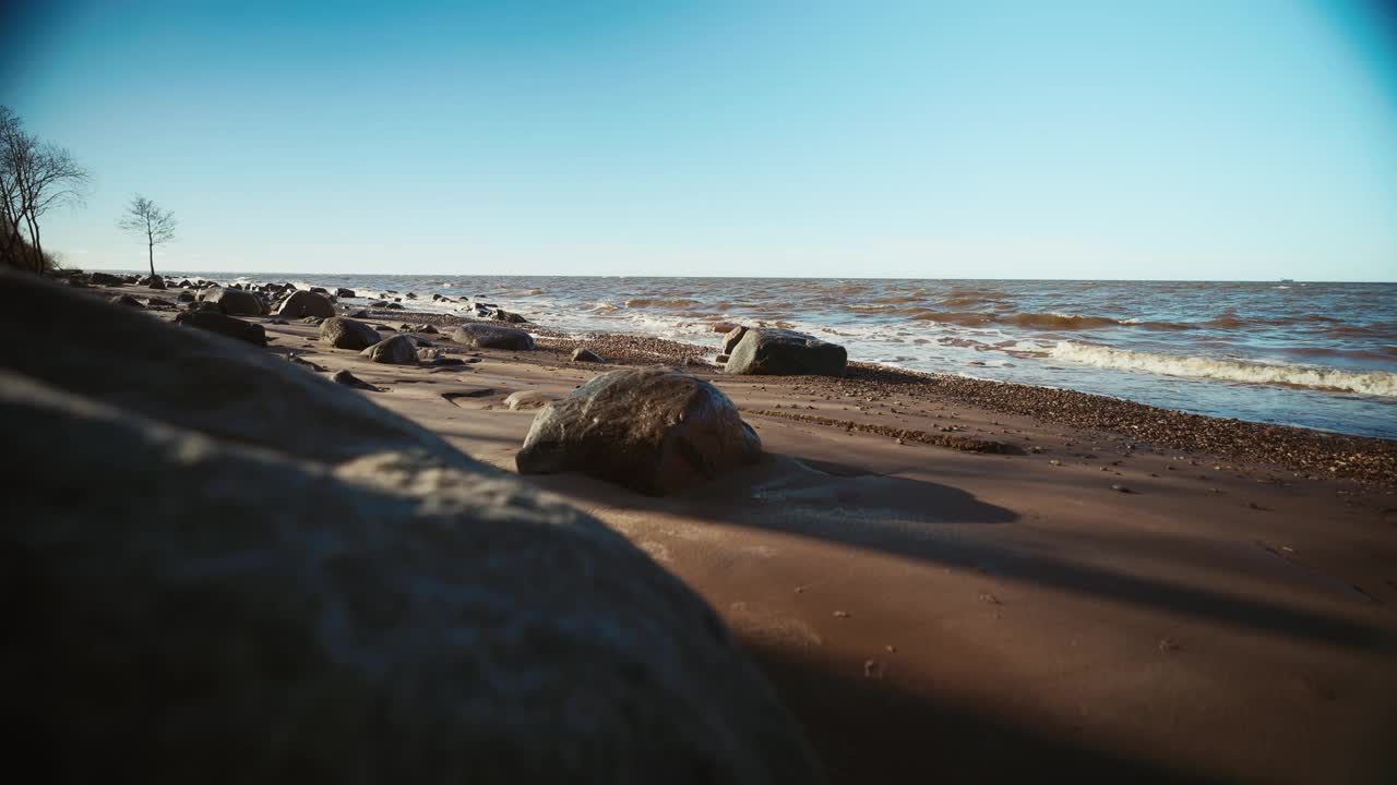 模糊的海滩景观与岩石在前景和海洋在背景视频素材