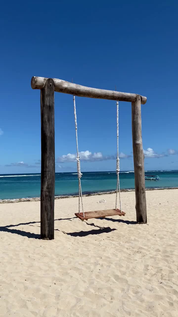 沙滩上的蓝天衬托着空秋千。视频下载