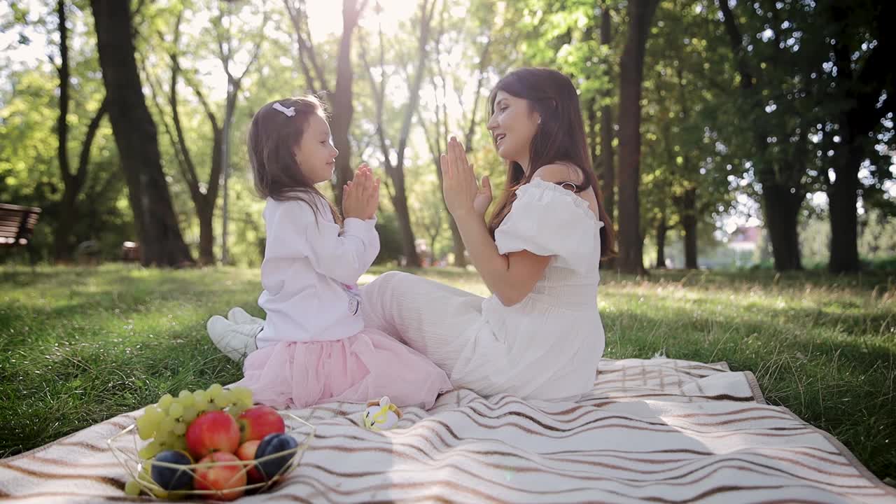 女儿和妈妈在公园外面用手玩游戏。玩掌心，拍手，共度时光视频素材