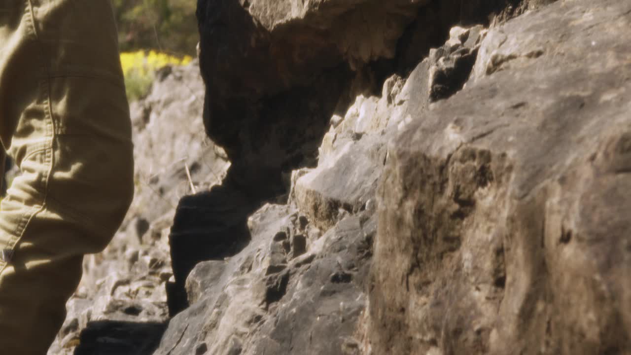 勇敢的登山者攀登崎岖的地形:在广角电影的慢动作捕捉视频素材