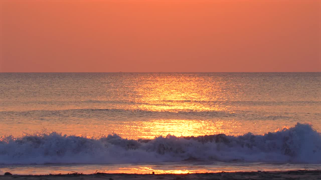 宁静的日落景观在平静的海浪。鲜艳的橙色和视频素材