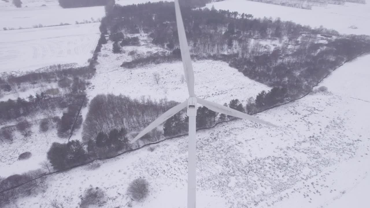 冬天的乡村，风力涡轮机在雪地上旋转。-航拍视频素材