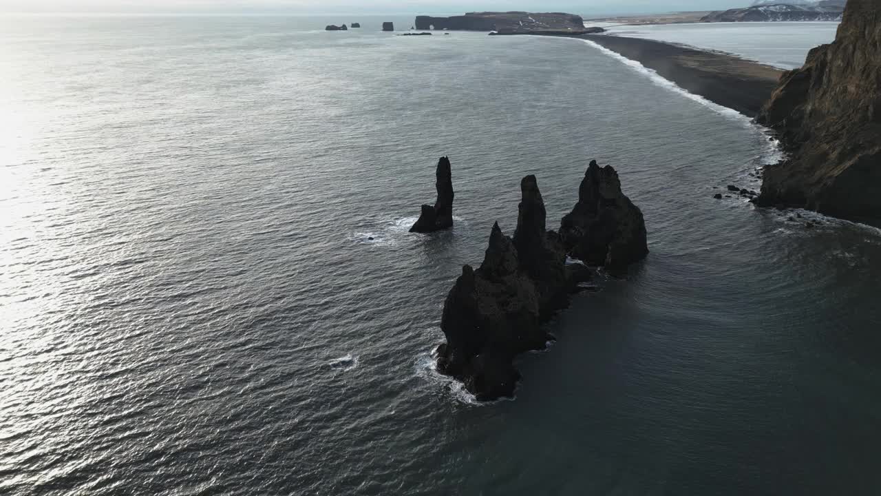 无人机向下倾斜在Reynisfjara黑沙滩上的Reynisdrangar Seastacks上视频素材