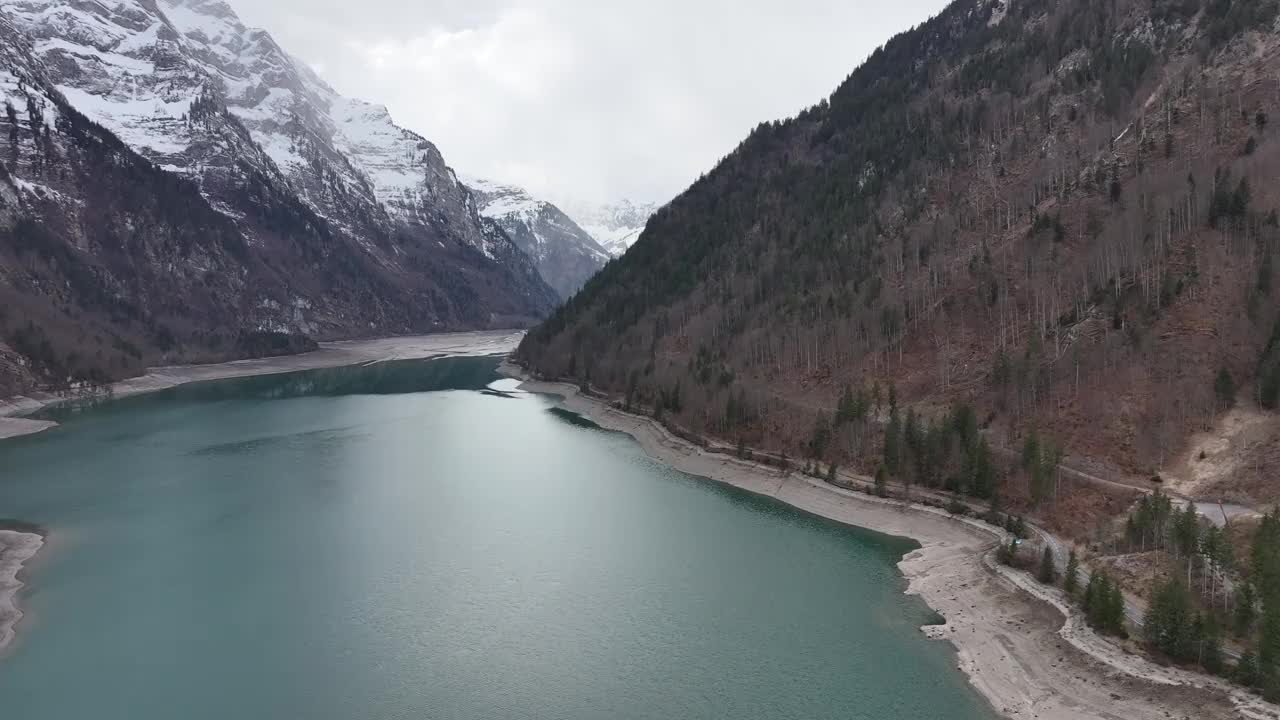 俯瞰瑞士格拉鲁斯的Klöntalersee, Vorderglärnisch山高耸在山谷湖泊之上，周围是白雪皑皑的山峰，展示了瑞士阿尔卑斯山的魅力。视频素材