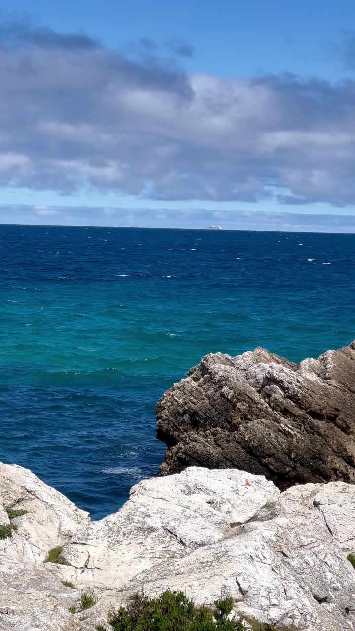 视频宁静的海景从岩石悬崖与多云的蓝天头顶。视频素材