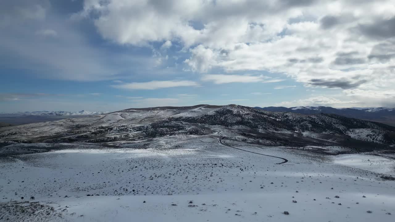 鸟瞰图，铺砌的狭窄道路穿过美国内华达州北部广阔的雪原视频素材