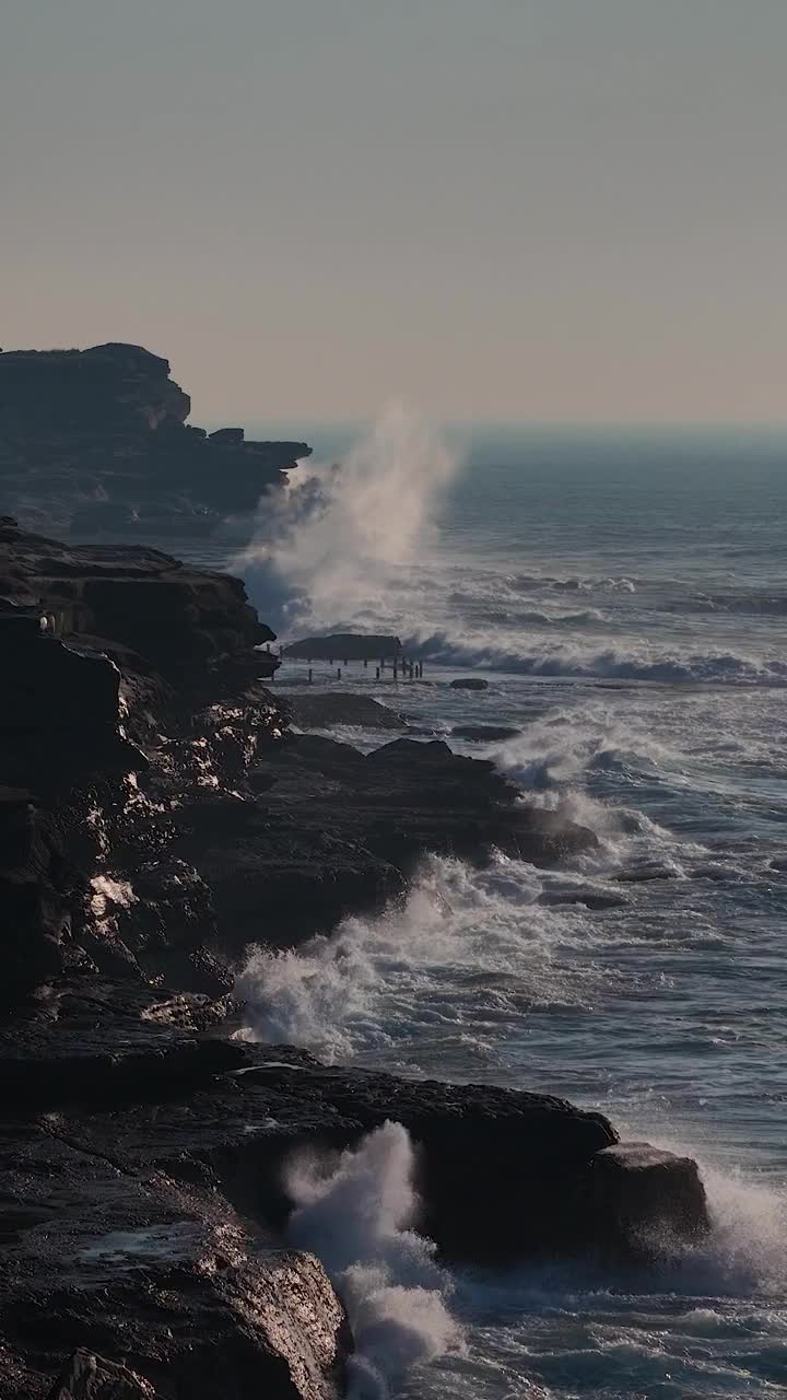 澳大利亚马鲁布拉海滩，日落时海浪冲击岩石的垂直慢动作镜头视频素材