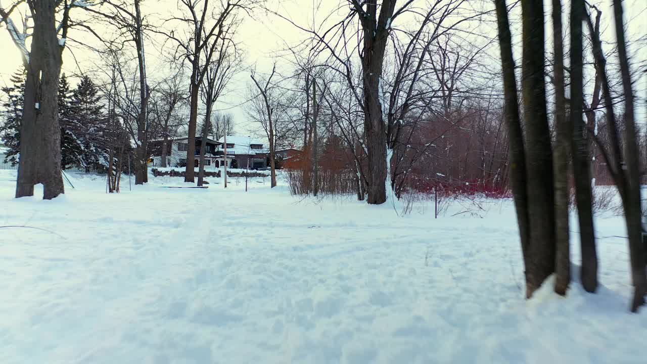 在拉瓦尔西部的一条步道上，在雪地上留下的脚印上快速地向后飞行视频下载