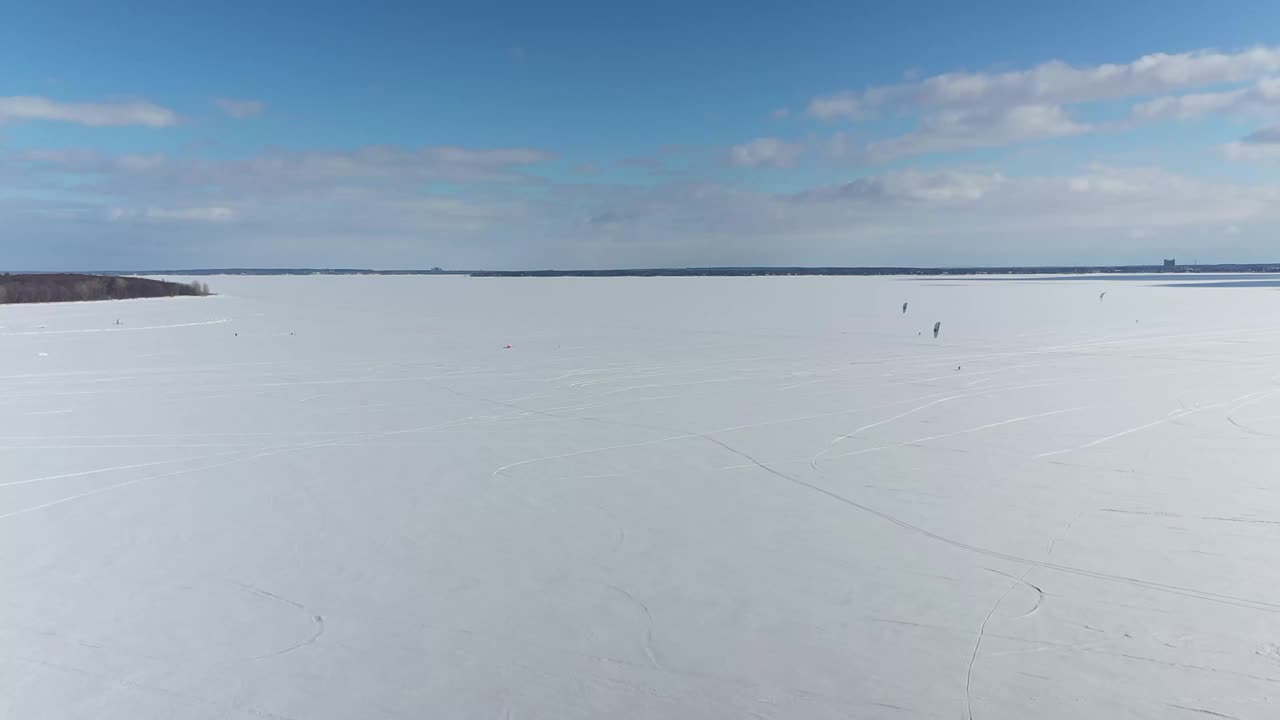 高空无人机拍摄，在两山冰冻湖的冰面上跟随风筝冲浪者时侧身移动，Oka-24 fps视频素材