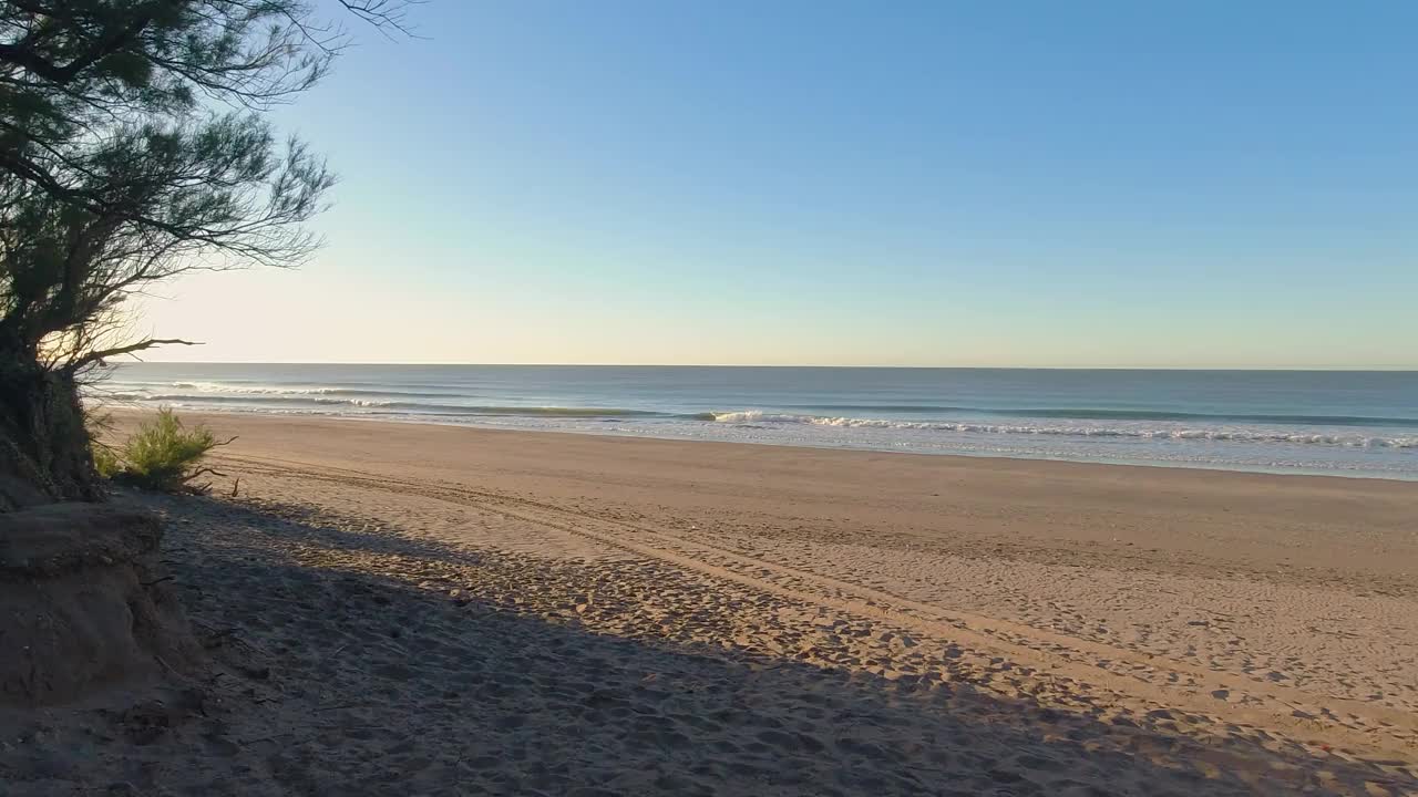 海滩，海浪轻轻移动，蓝天和阳光视频素材